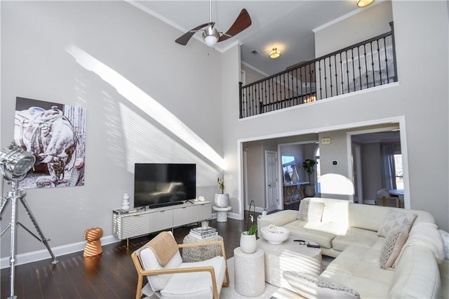 living room featuring ceiling fan, hardwood / wood-style floors, crown molding, and a high ceiling