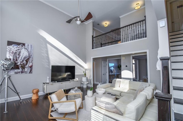 living room featuring ceiling fan, a towering ceiling, ornamental molding, and hardwood / wood-style flooring