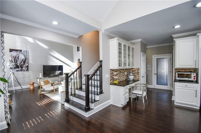 stairway featuring hardwood / wood-style floors, ornamental molding, and lofted ceiling