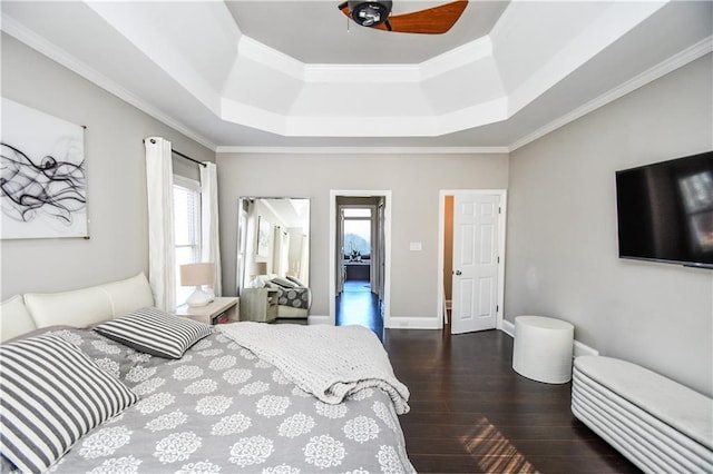 bedroom featuring a raised ceiling, ceiling fan, dark wood-type flooring, and ornamental molding