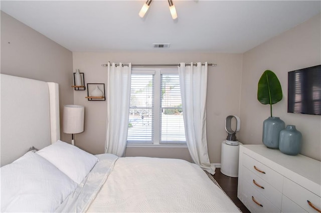 bedroom featuring multiple windows, dark wood-type flooring, and ceiling fan