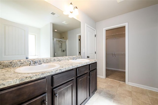 bathroom with visible vents, a sink, a shower stall, and double vanity