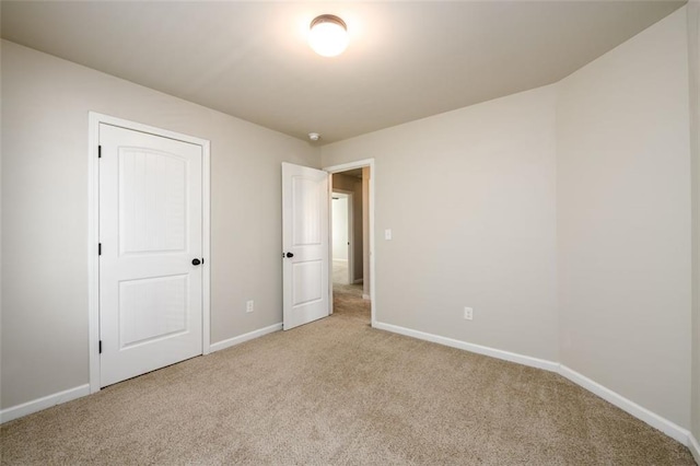 unfurnished bedroom with baseboards and light colored carpet