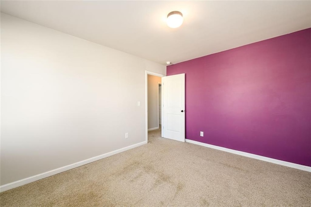 spare room with baseboards and carpet flooring