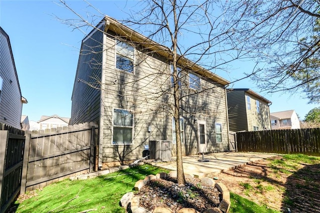 back of house featuring a patio area, a yard, a fenced backyard, and central air condition unit