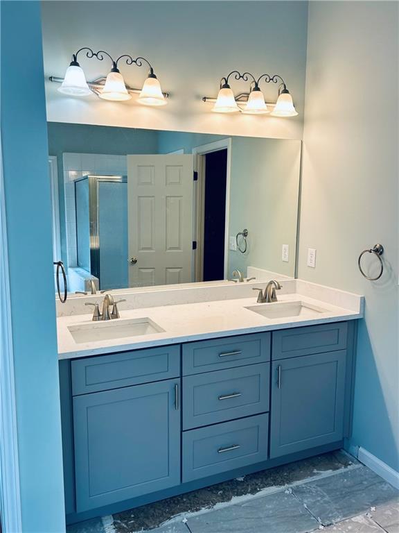 6605 New Ridge Ct, Cumming, GA 30041 - full bath featuring a stall shower, double vanity, and baseboards