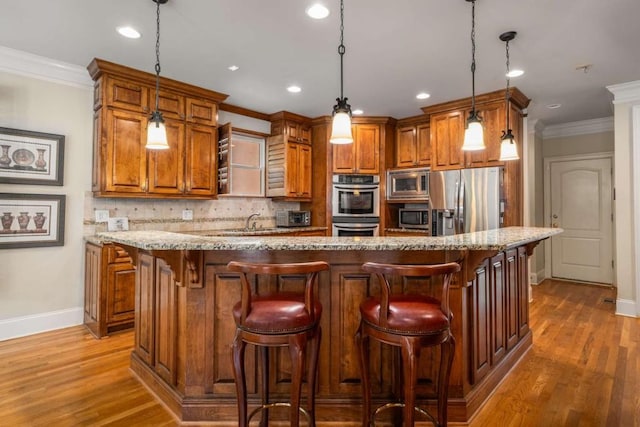 kitchen with pendant lighting, a kitchen island, stainless steel appliances, and wood-type flooring