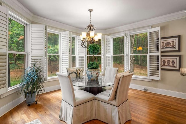 dining room featuring light hardwood / wood-style floors, an inviting chandelier, and ornamental molding