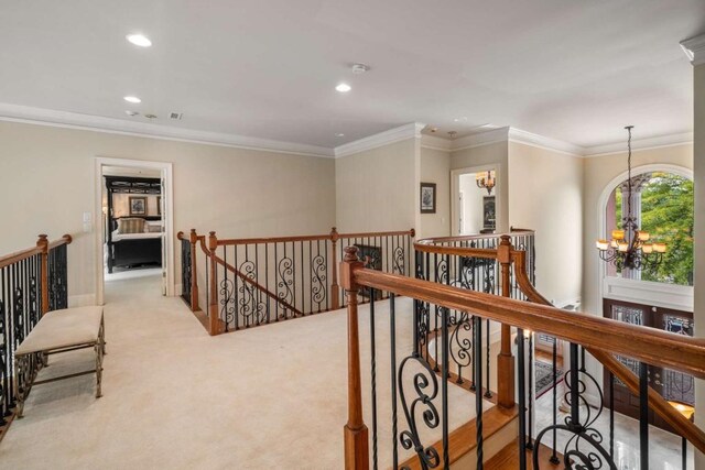 corridor with crown molding, light carpet, and a chandelier