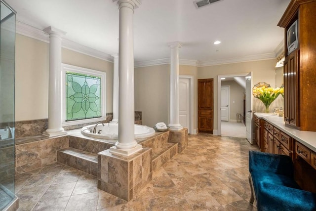 bathroom featuring vanity, tiled bath, decorative columns, and ornamental molding