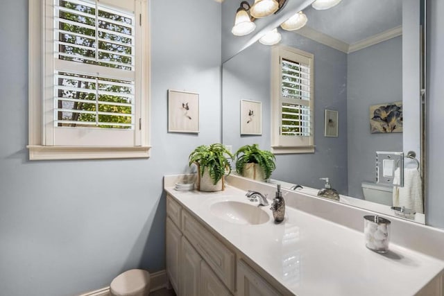 bathroom featuring vanity, toilet, and ornamental molding