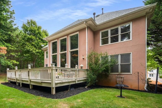 back of house featuring a lawn and a wooden deck