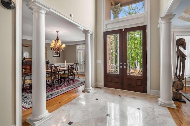 entryway featuring ornamental molding, french doors, wood-type flooring, and an inviting chandelier