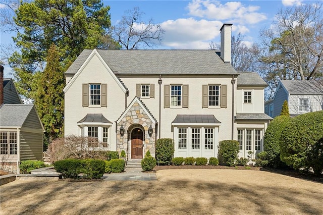 view of front of house featuring stone siding and a chimney