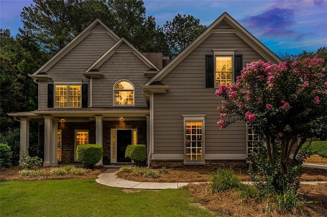 view of front of house with a porch and a lawn