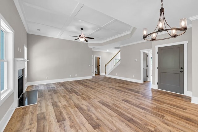 unfurnished living room featuring light hardwood / wood-style floors, ceiling fan with notable chandelier, and coffered ceiling