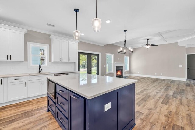 kitchen with light hardwood / wood-style flooring, white cabinetry, sink, pendant lighting, and blue cabinets