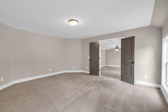 carpeted spare room with ceiling fan and lofted ceiling