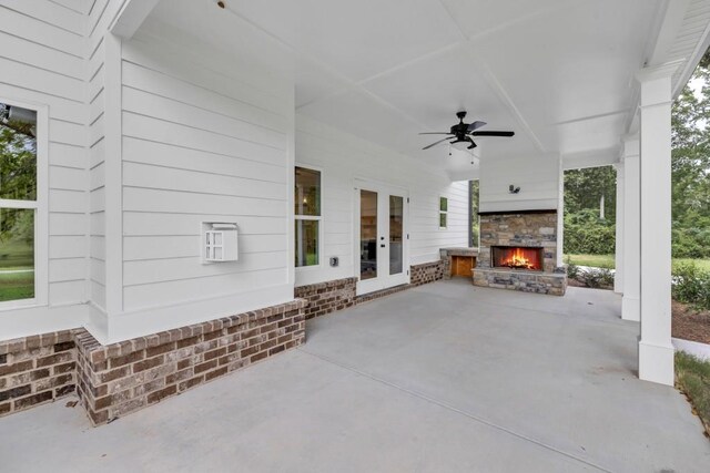 view of patio with ceiling fan, french doors, and an outdoor stone fireplace