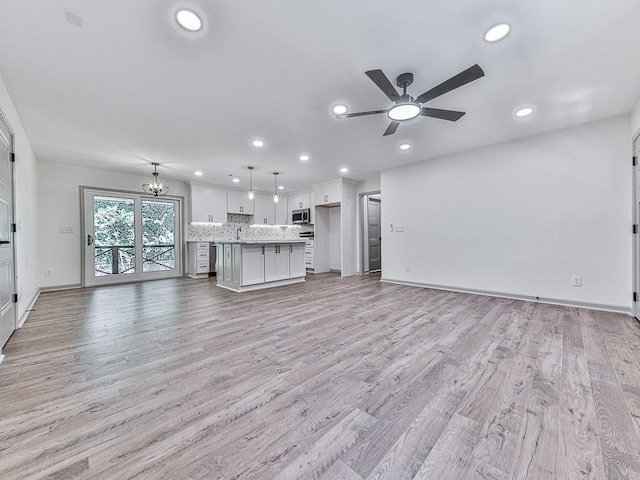 221 Wonewok Dr, Canton, GA 30114 - unfurnished living room featuring ceiling fan, recessed lighting, light wood-style flooring, and a chandelier