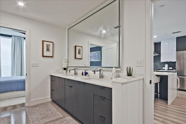 living room featuring sink and light hardwood / wood-style flooring