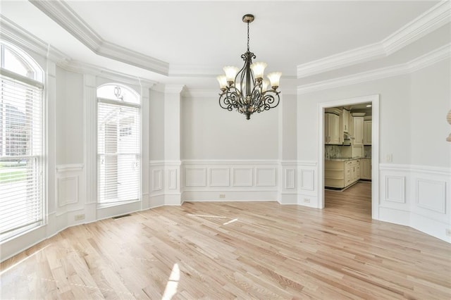 5121 Hope Ct SW, Lilburn, GA 30047 - spare room featuring a chandelier, a decorative wall, light wood-style floors, ornamental molding, and a wainscoted wall