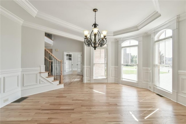 5121 Hope Ct SW, Lilburn, GA 30047 - unfurnished dining area featuring a raised ceiling, a chandelier, a decorative wall, crown molding, and light wood-style flooring