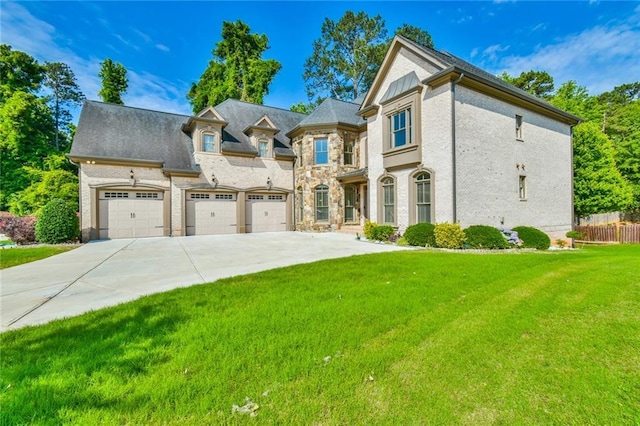 5121 Hope Ct SW, Lilburn, GA 30047 - french country inspired facade with driveway, an attached garage, and stone siding