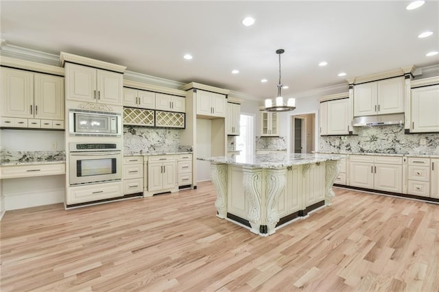 5121 Hope Ct SW, Lilburn, GA 30047 - kitchen with stainless steel appliances, under cabinet range hood, crown molding, backsplash, and light wood-style floors