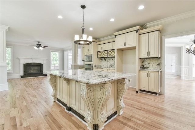 5121 Hope Ct SW, Lilburn, GA 30047 - kitchen featuring a chandelier, appliances with stainless steel finishes, cream cabinetry, tasteful backsplash, and crown molding