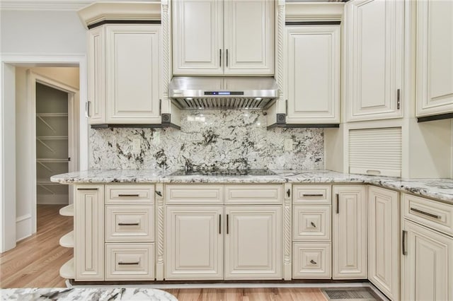 5121 Hope Ct SW, Lilburn, GA 30047 - kitchen with extractor fan, black stovetop, tasteful backsplash, and light wood-style floors