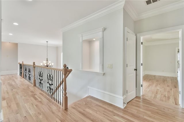 5121 Hope Ct SW, Lilburn, GA 30047 - hall with a chandelier, wood finished floors, crown molding, baseboards, and an upstairs landing