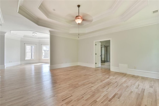5121 Hope Ct SW, Lilburn, GA 30047 - empty room featuring a raised ceiling, crown molding, light wood-style flooring, ceiling fan, and baseboards