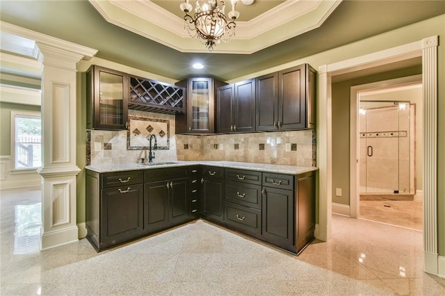 5121 Hope Ct SW, Lilburn, GA 30047 - bar with a sink, crown molding, a chandelier, tasteful backsplash, and granite floors