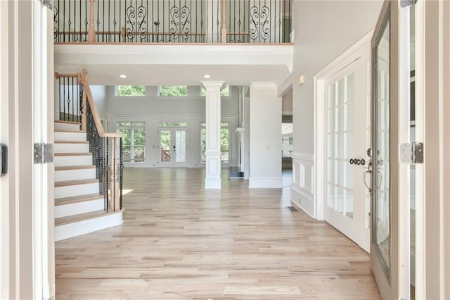 5121 Hope Ct SW, Lilburn, GA 30047 - entrance foyer with french doors, a towering ceiling, light wood-style flooring, stairway, and decorative columns
