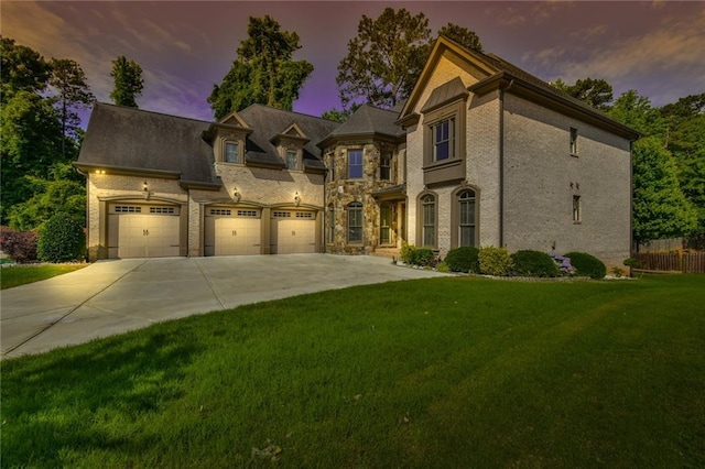 5121 Hope Ct SW, Lilburn, GA 30047 - view of front facade featuring driveway, a lawn, stone siding, and an attached garage