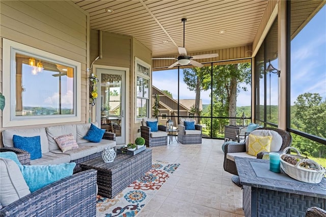 sunroom featuring a healthy amount of sunlight, wood ceiling, and ceiling fan