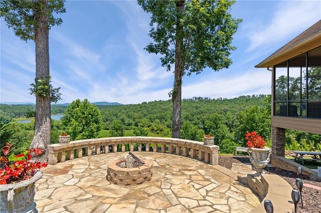 view of patio / terrace with a sunroom and an outdoor fire pit