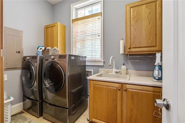 clothes washing area featuring sink, cabinets, a wealth of natural light, and separate washer and dryer