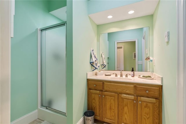 bathroom featuring tile patterned flooring, a shower with door, and vanity