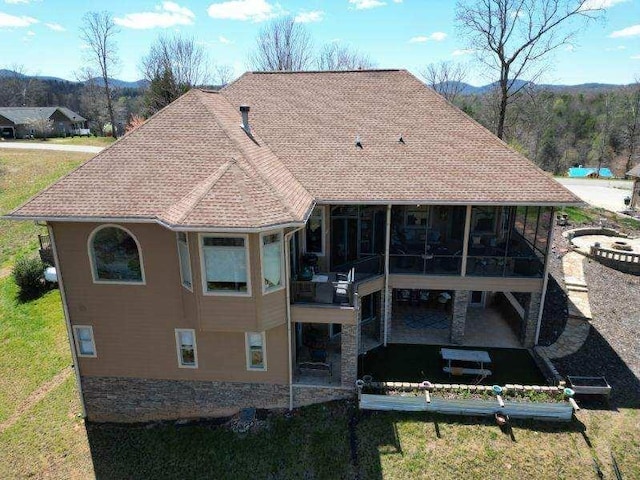 back of property with a sunroom and a yard