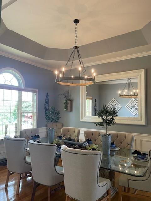 dining room featuring a raised ceiling, hardwood / wood-style floors, and a chandelier