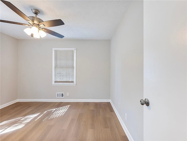 spare room with ceiling fan and light wood-type flooring