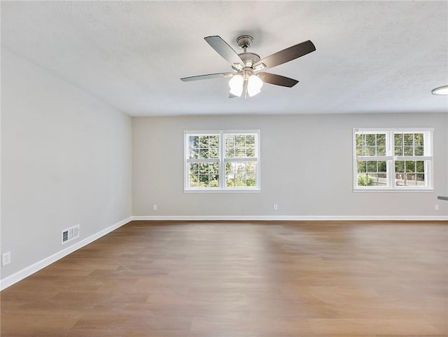 unfurnished room featuring ceiling fan, plenty of natural light, and light wood-type flooring