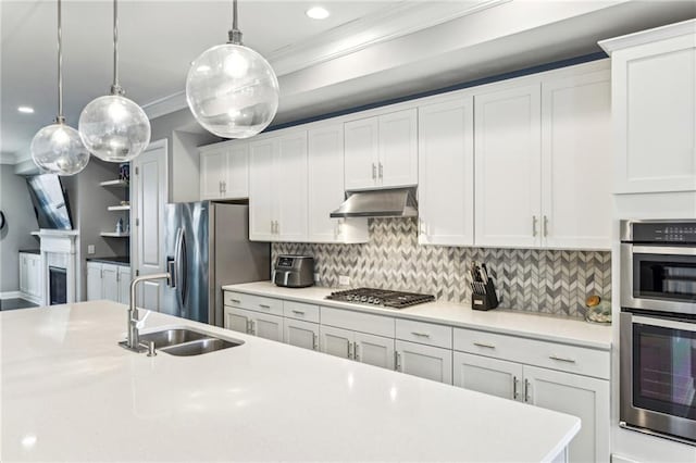 kitchen featuring crown molding, stainless steel appliances, light countertops, a sink, and under cabinet range hood