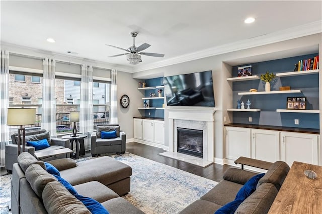 living room featuring dark wood-style flooring, crown molding, and a high end fireplace