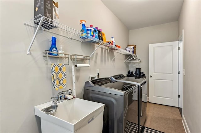 laundry room featuring laundry area, baseboards, washer and clothes dryer, and a sink