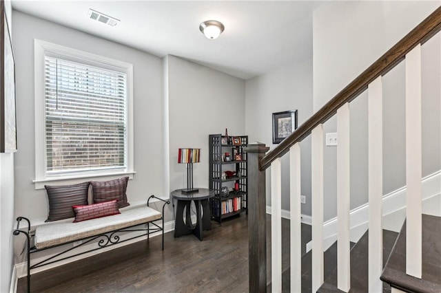 interior space featuring stairway, baseboards, dark wood-style floors, and visible vents