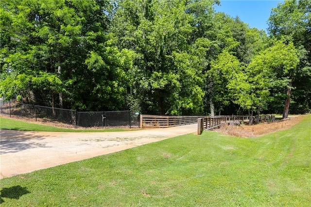 view of community featuring a yard and fence