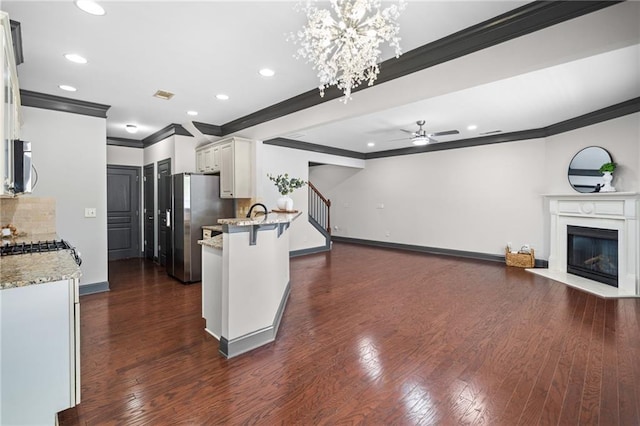 775 Duberry St, Alpharetta, GA 30004 - kitchen with crown molding, stainless steel appliances, a ceiling fan, a peninsula, and white cabinetry